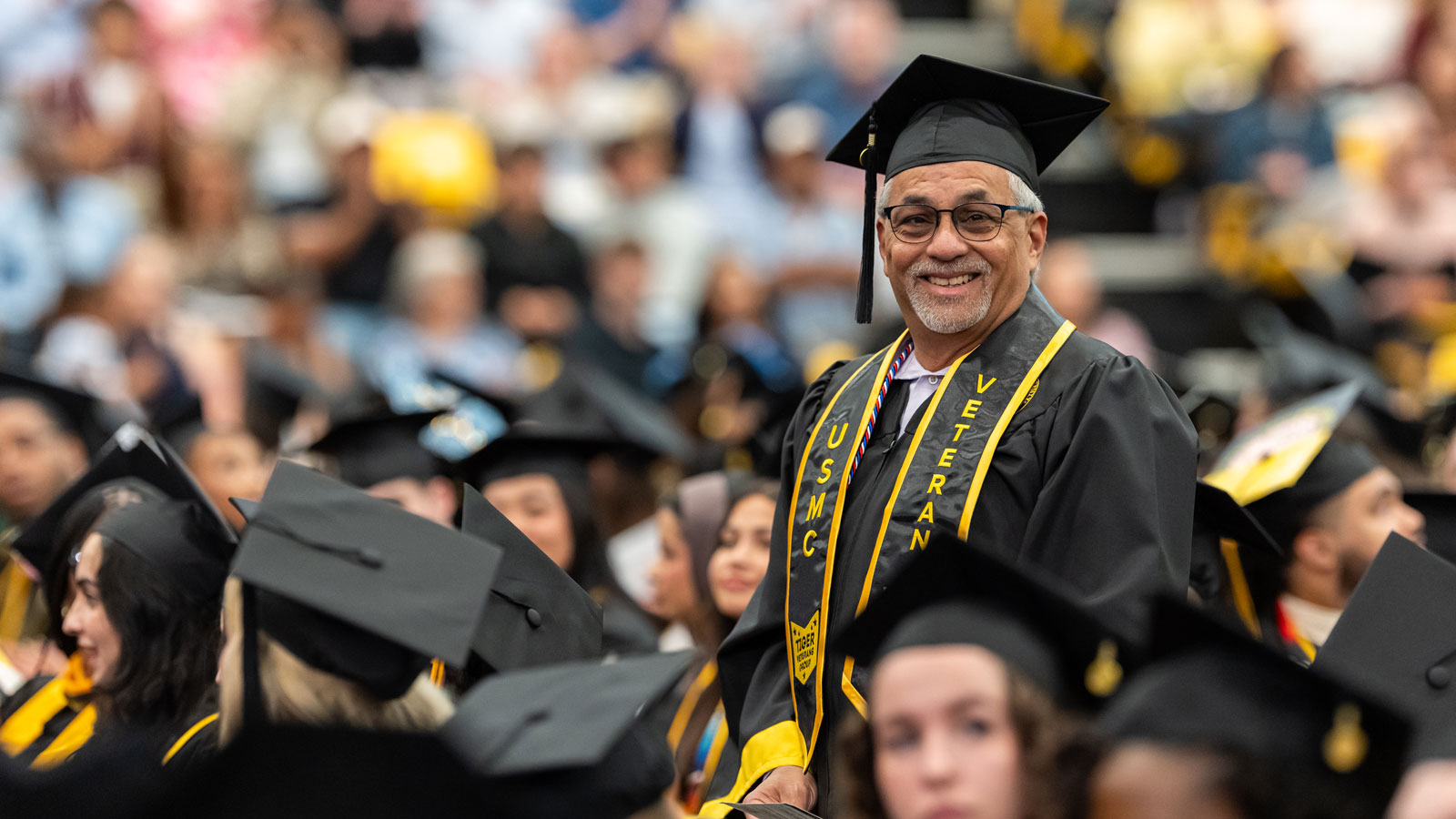 Ricardo Batiz '26, standing and being recognized at the 2026 Towson University Commencement Ceremony