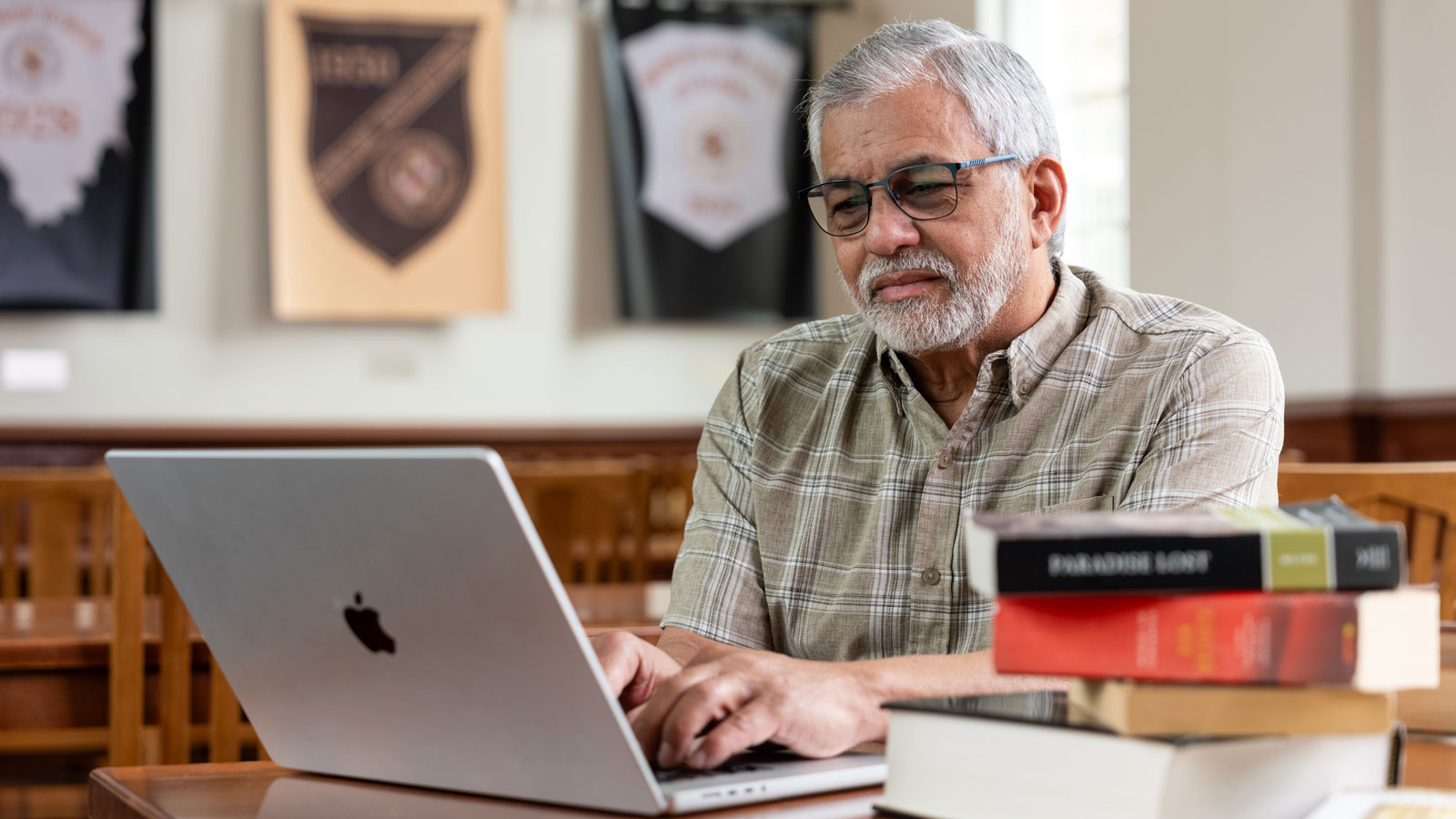 Ricardo Batiz '26, sitting in a campus office at a computer and writing