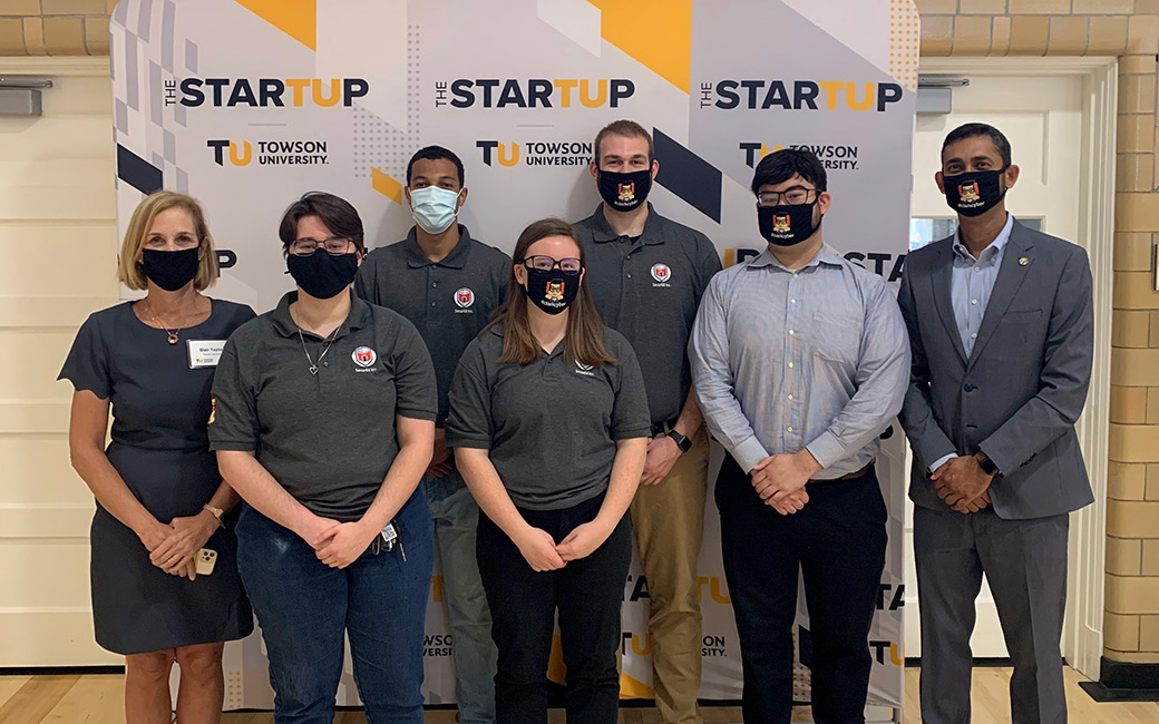 Team of people standing in front of StarTUp sign