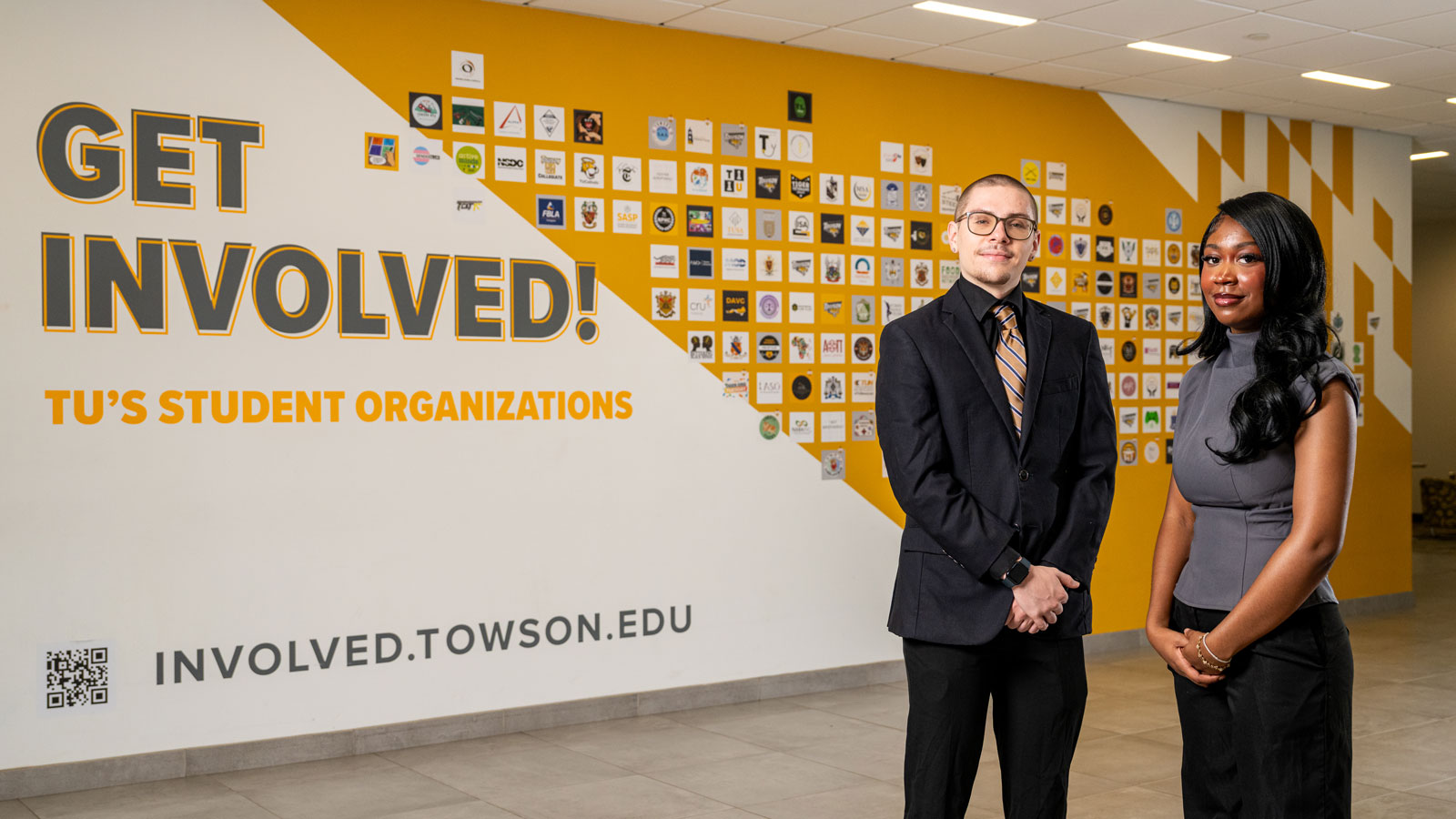 TU SGA President and VP in front of the wall of student organizations