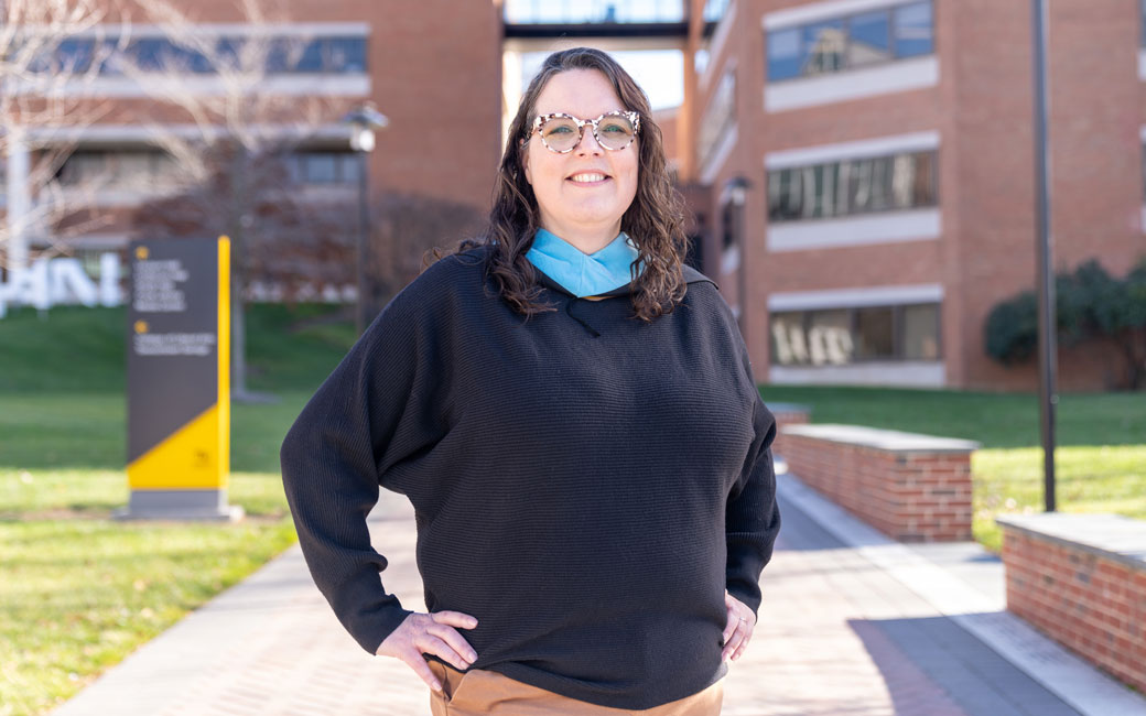 Woman doctoral stands outside of the Psychology building