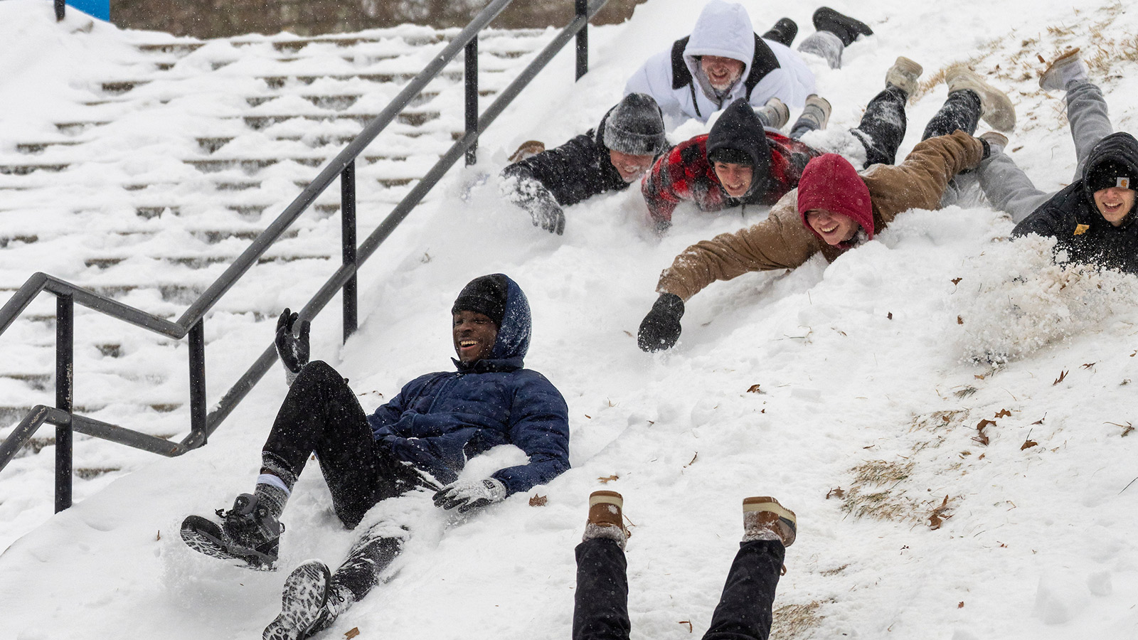 tigertowson university students sledding down a snowy hill