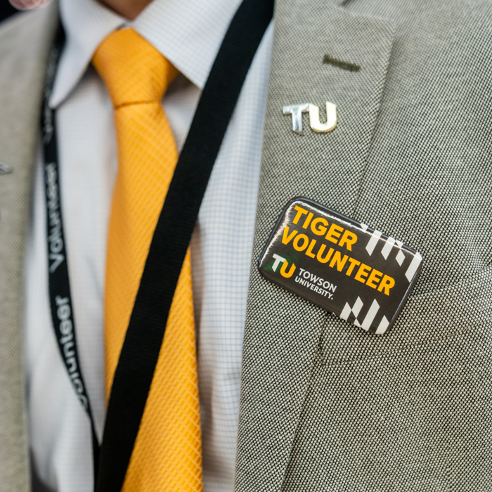 Close up image of a staff member's Volunteer lapel pin