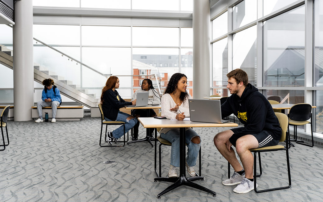 students at table indoors with laptop