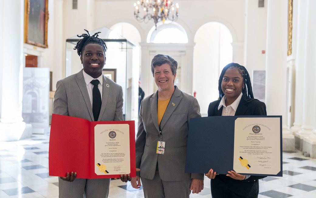Students and Interim President Melanie Perreault pose with Tiger Pride Day proclamations
