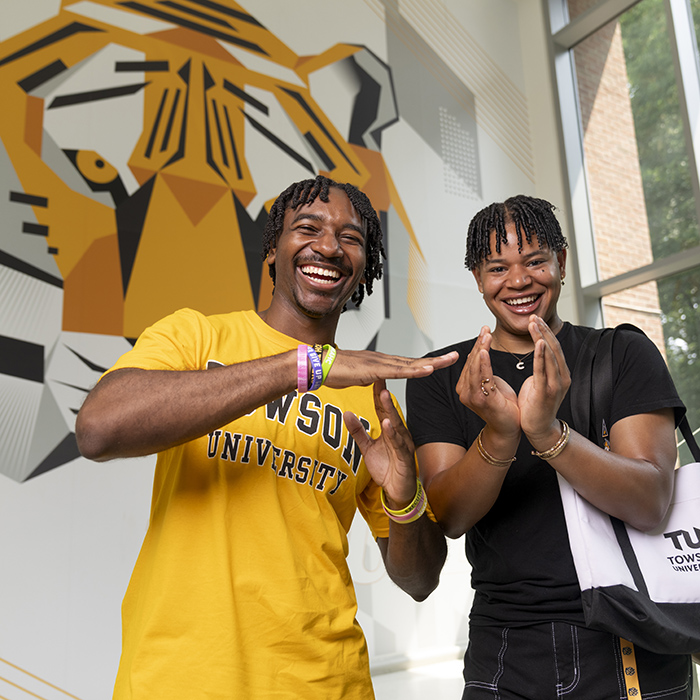 two TU students forming a T and U with their hands