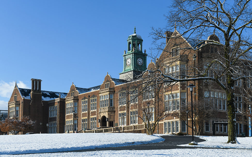 Stephens Hall with snow-covered grass and blue sky