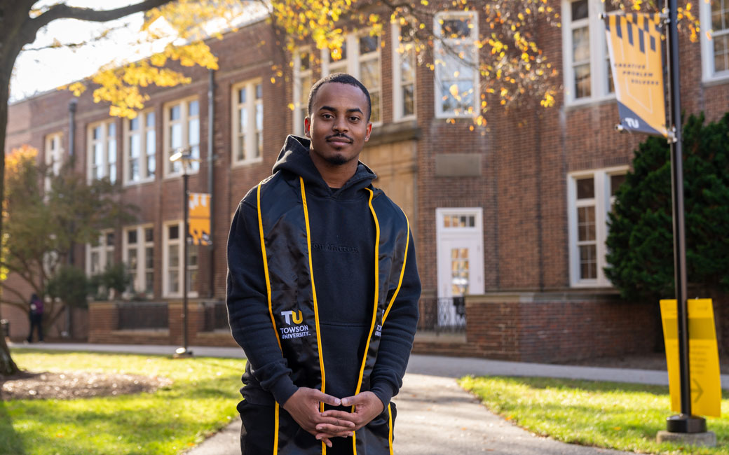 Student stands outside of Van Bokkelen Hall