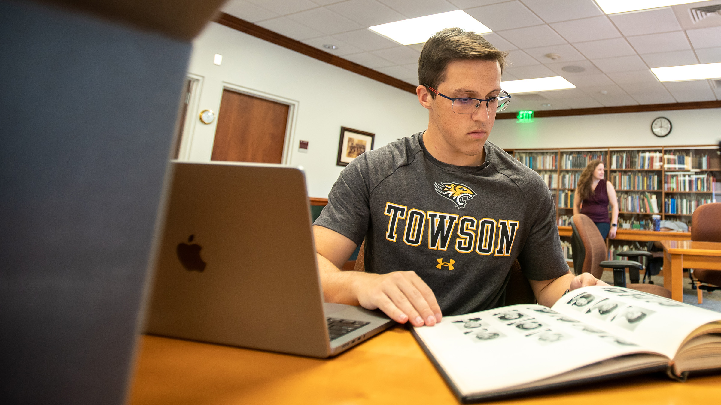 male student reading through a history book