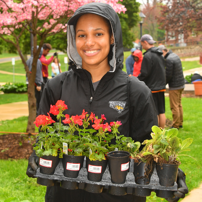 student planting flowers on campus