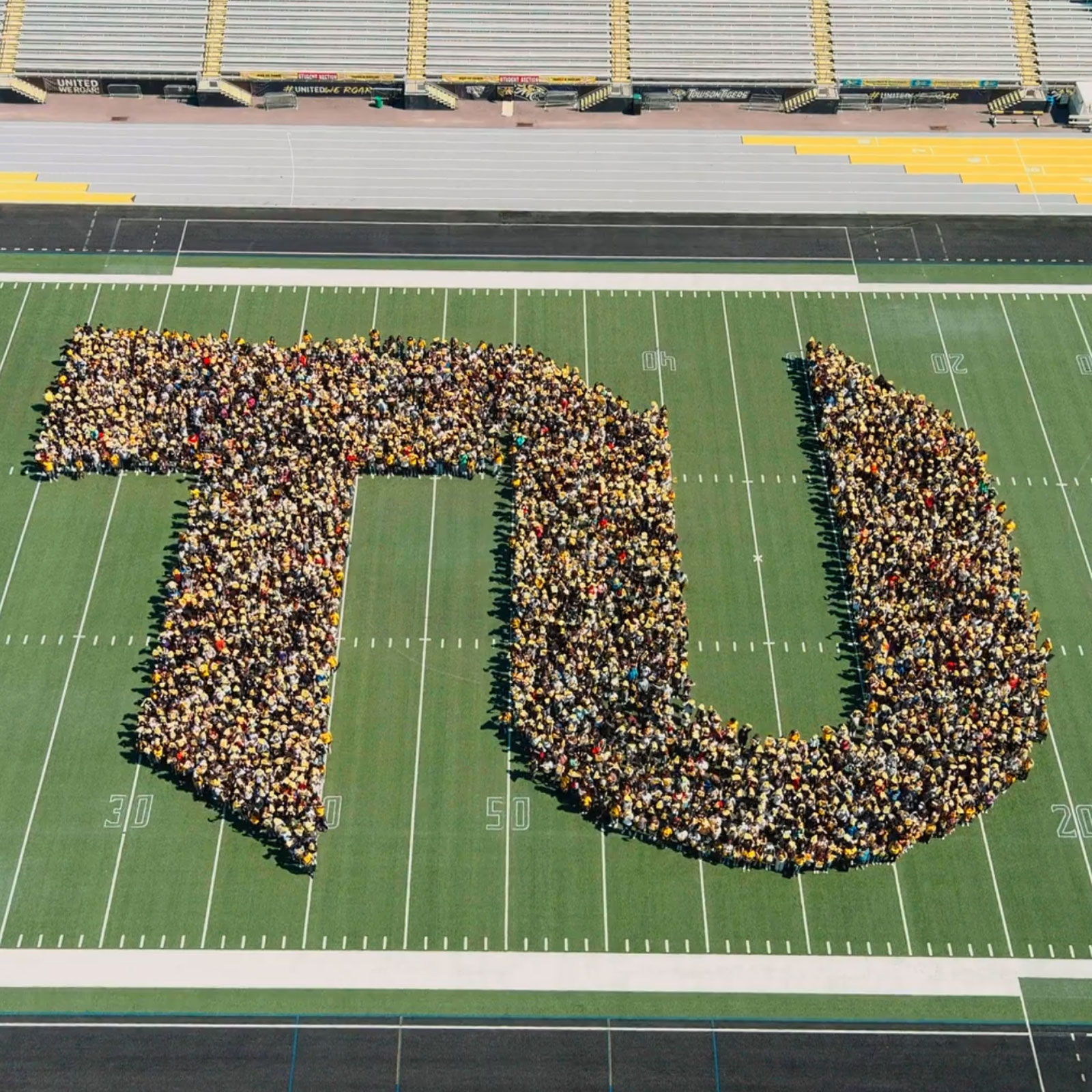 Aerial shot of the incoming class standing on the football field making the TU logo