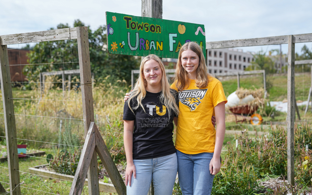 Two students stand in front of Towson University's Urban Farm