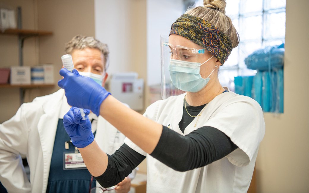 Nursing student Katie Lastova pulls a dose of Moderna vaccine