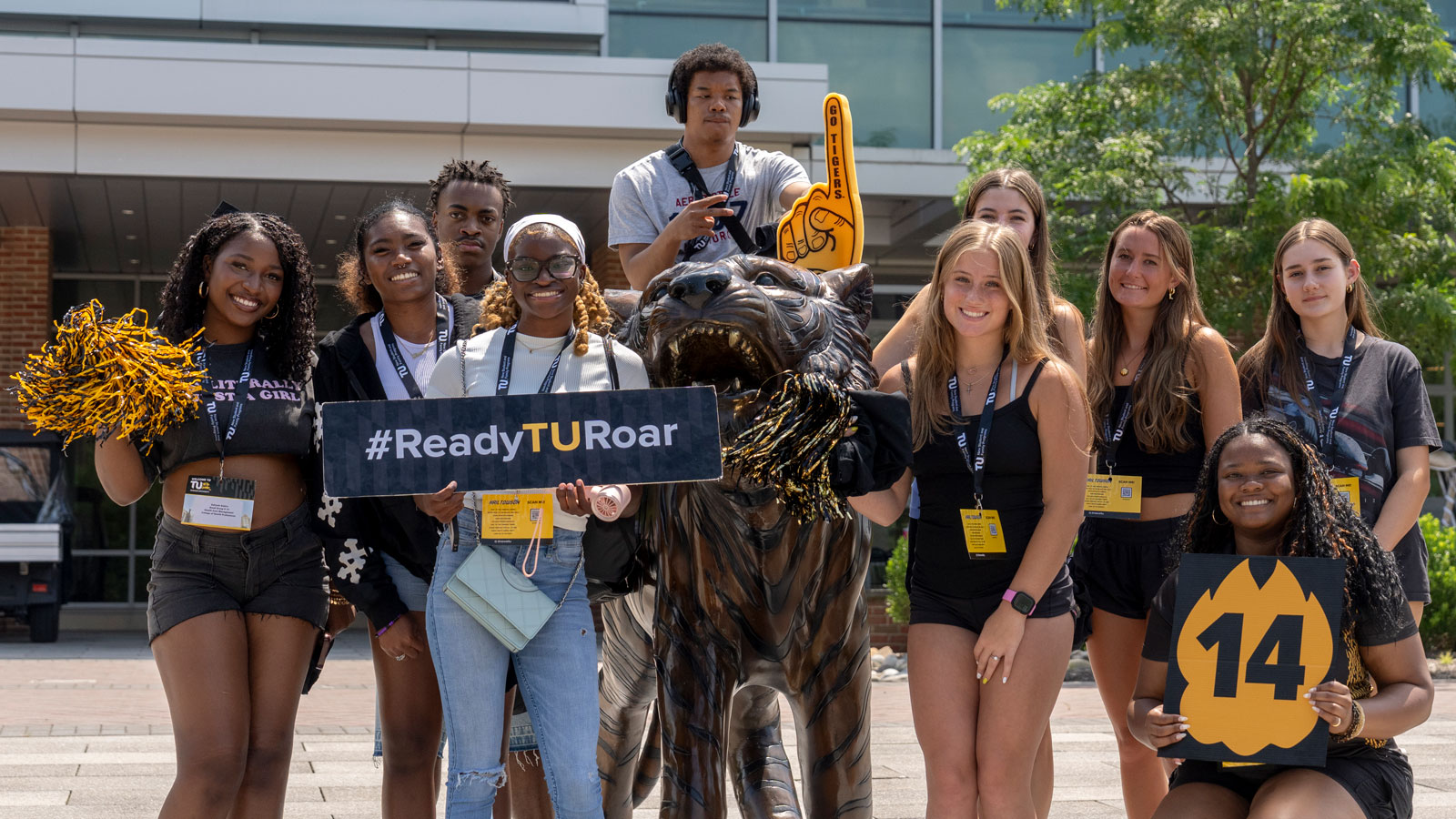 First Year Experience Student Leader poses with her orientation group in front of the Union tiger statue on campus