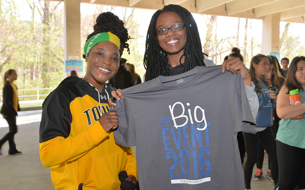 Students hold a The Big Event shirt.