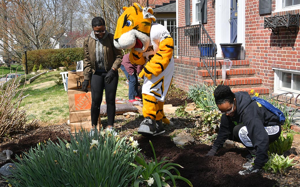 Doc and students plant a garden. 