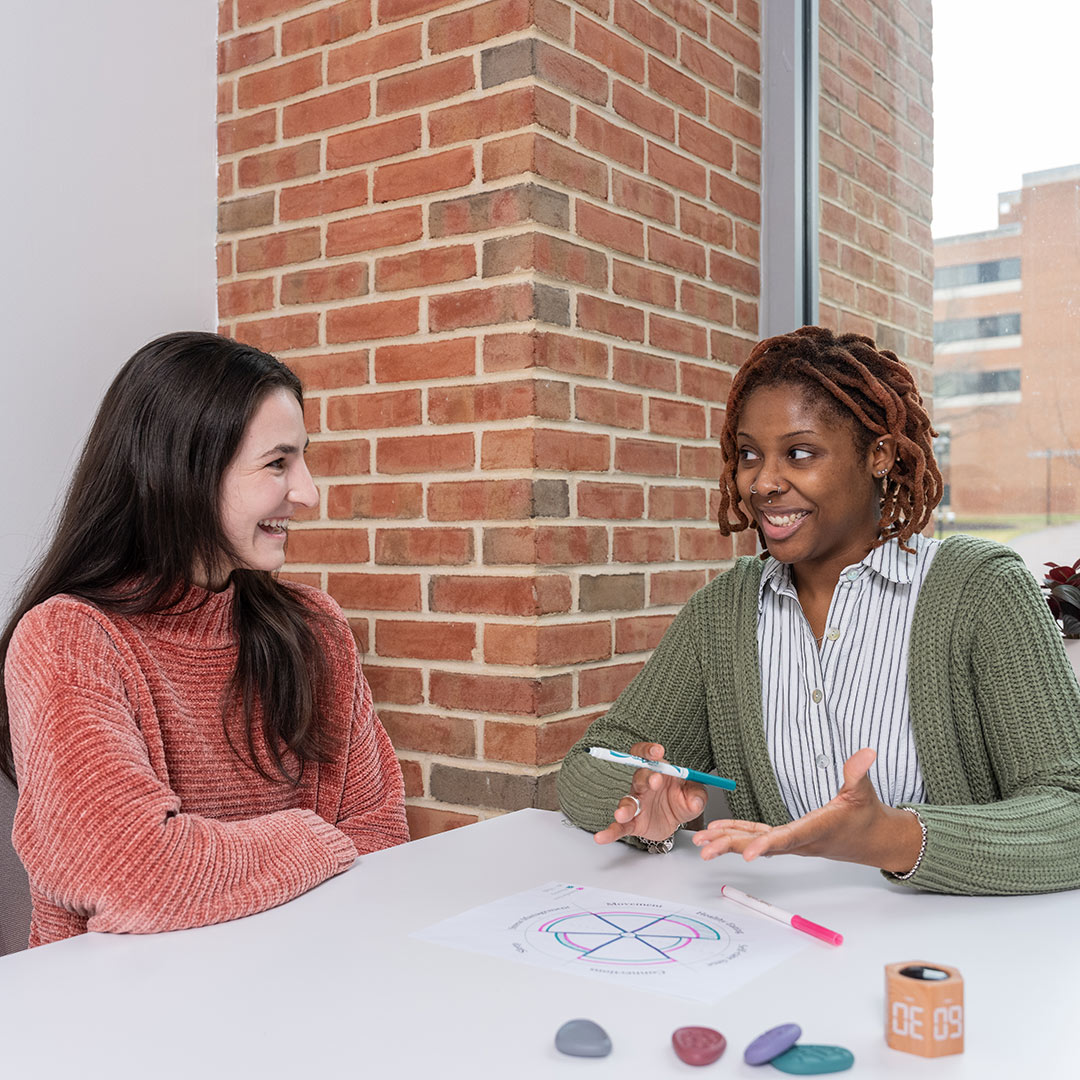 Two students sitting at table having a discussion