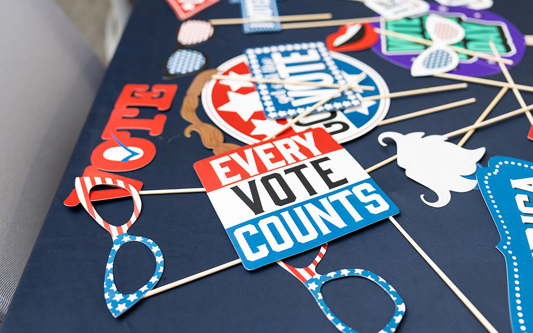 A TU Votes Coalition member shares voter information with two students. 