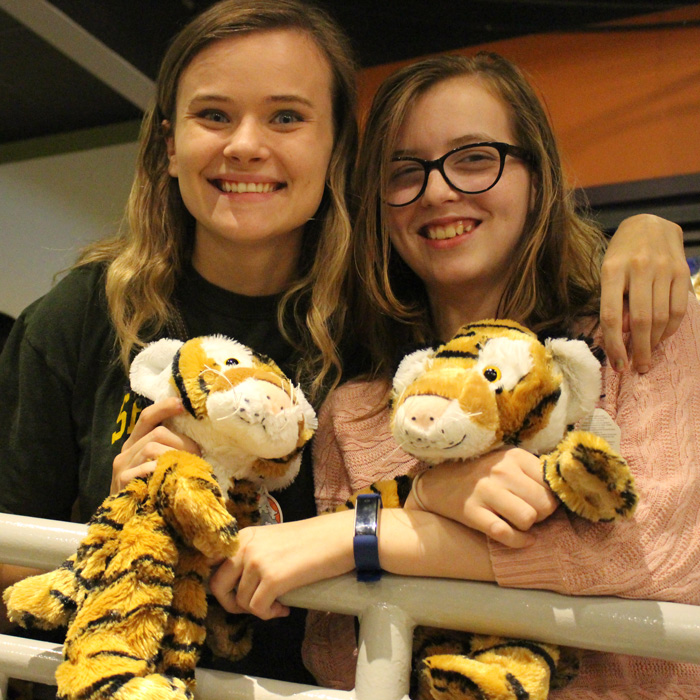 Two girls holding stuffed tigers