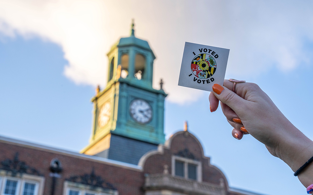 An "I Voted sticker" is displayed in front of the Stephens Hall Clock Tower.
