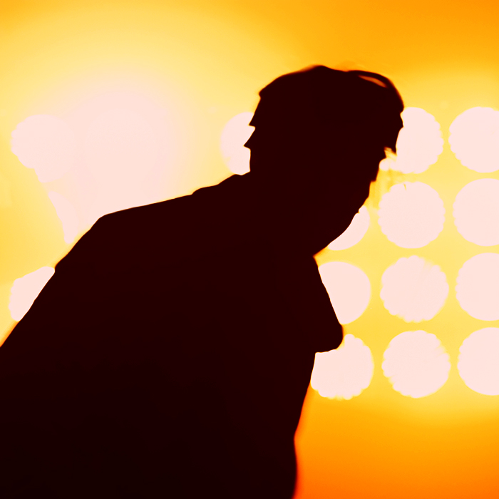 Figure standing in front of stage lights