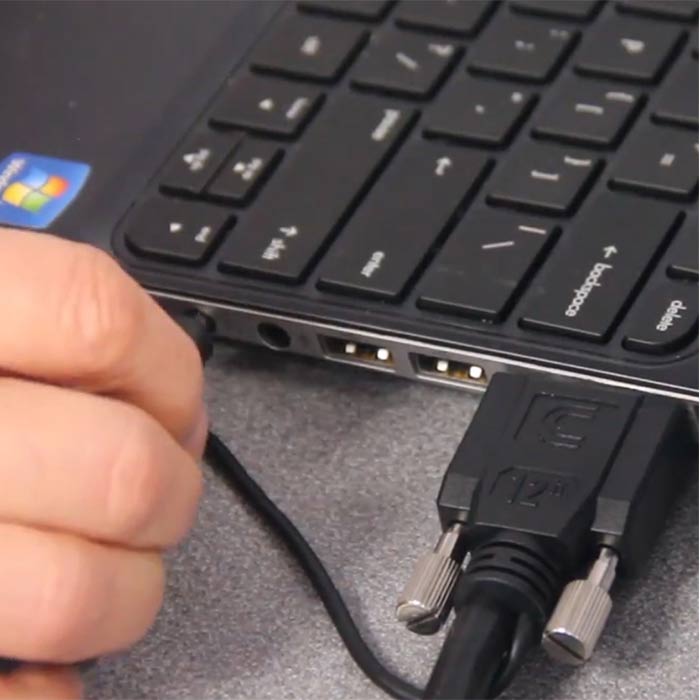 hand plugging a cord into a laptop