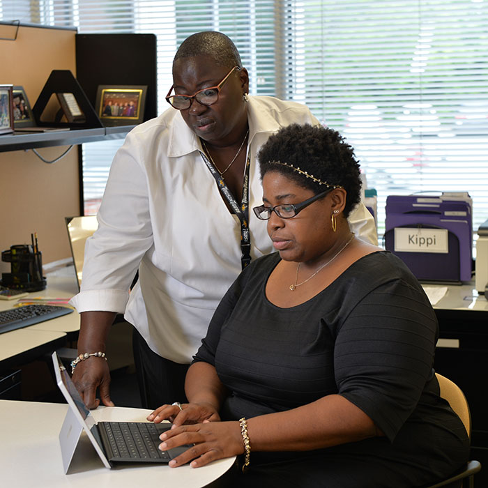 staff member recieving technology support at a desk